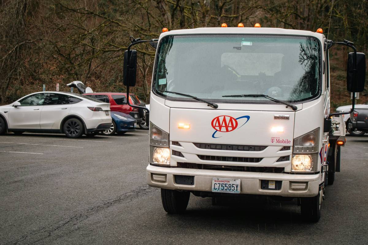 Driver using card aid repair service during nighttime breakdown with credit card in hand