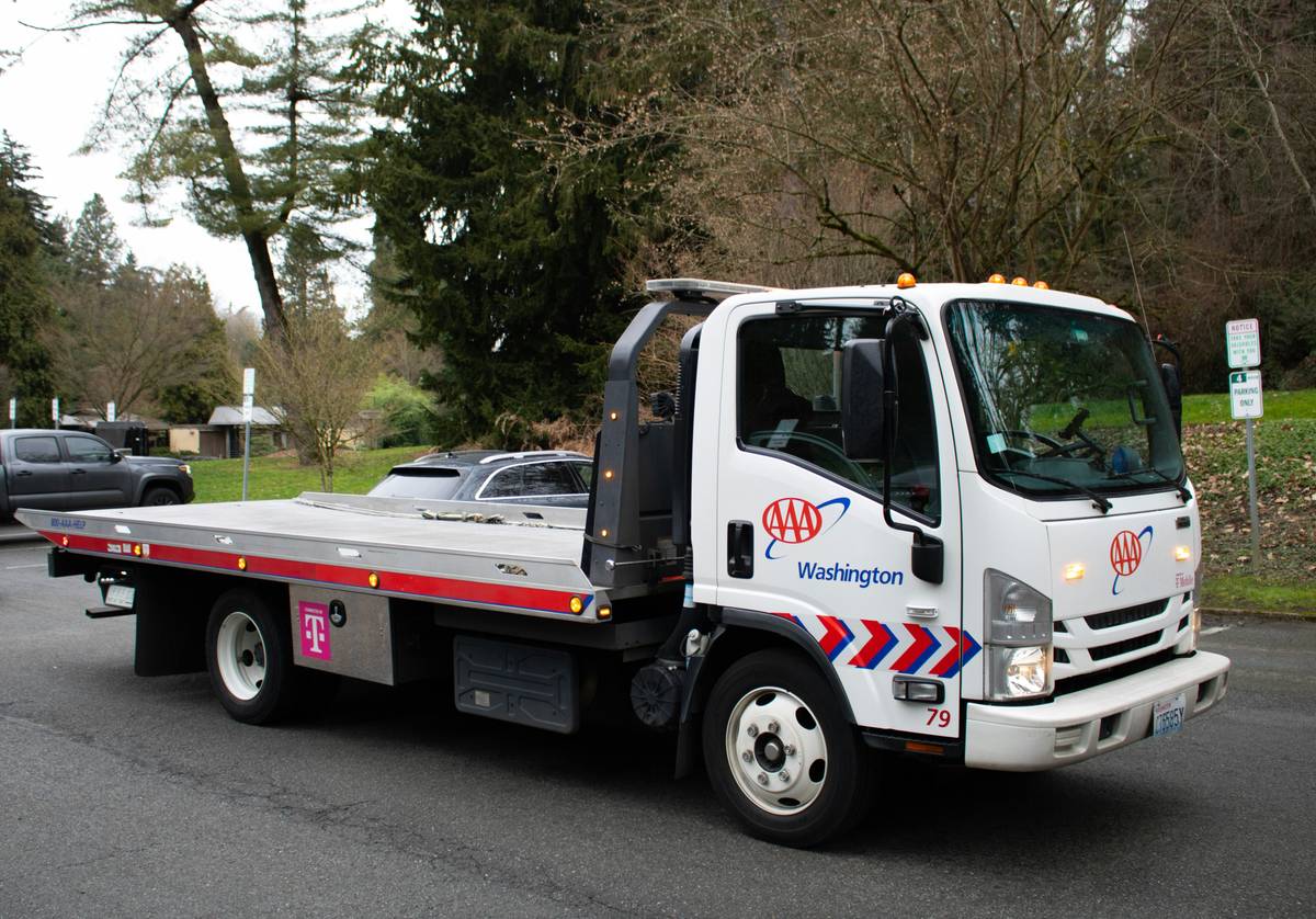 Driver using mobile app to coordinate credit limit towing with roadside assistance provider while avoiding extra fees